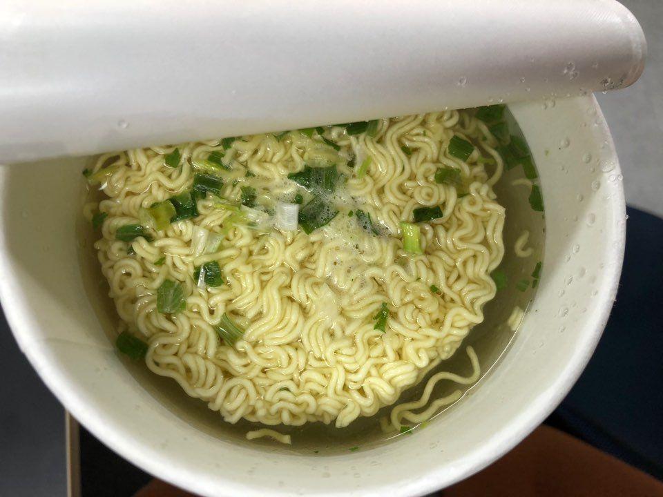 Cooked noodles of Omori Kimchi Jjigae Ramen with vibrant soup and vegetable garnish, demonstrating Korean traditional stew flavor.